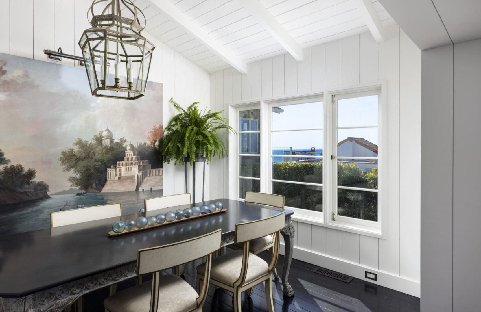 Dining table with hanging light on top with windows beside