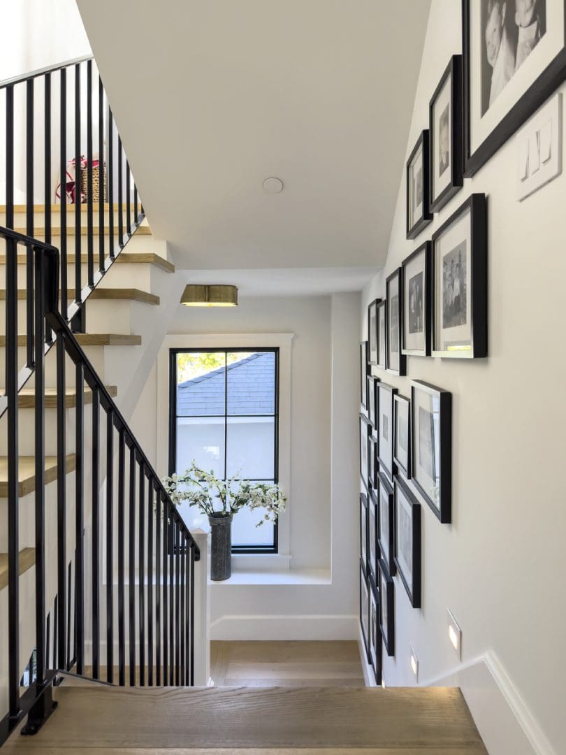 Numerous photo frames on wall beside stairs