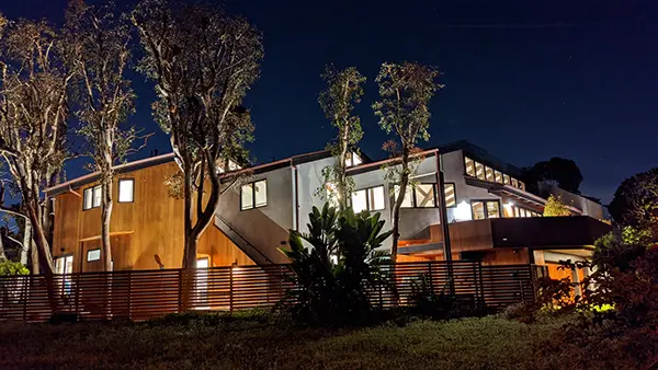 A modern house lit up at night.