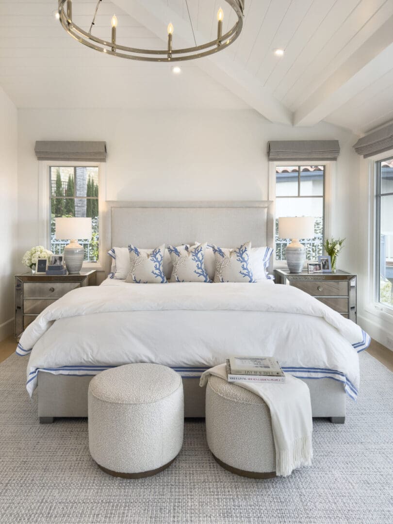 A white and gray bedroom with a chandelier.