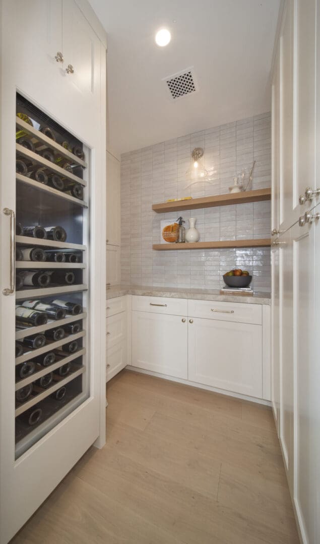 A white kitchen with a wine cooler in it.