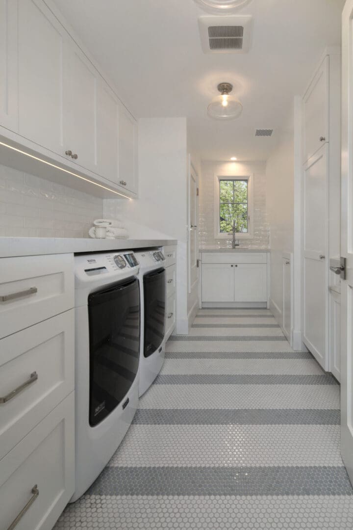 A white and gray laundry room with a washer and dryer.